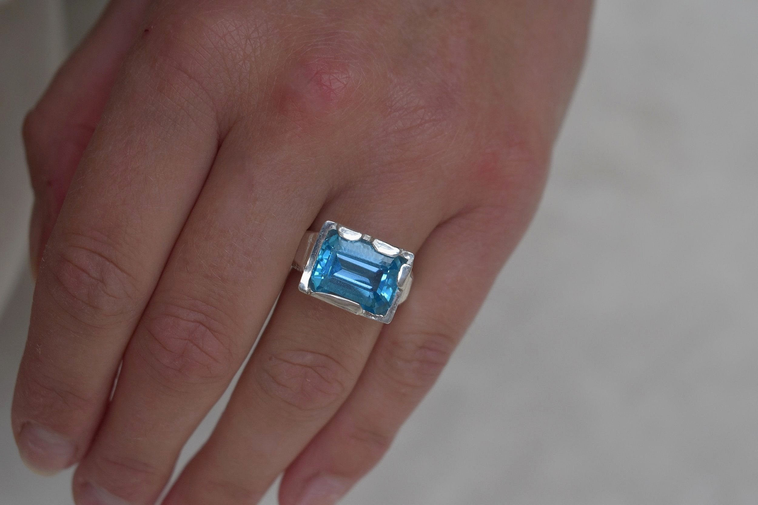 This is a beautiful emerald cut blue topaz set into a hand made solid silver setting. This stone is ethically sourced and the silver is 100% recycled
blue topaz statement ring cocktail party style large engagement ring in silver emerald cut stone ring diamond ring tiffany engagement sparkle silver stack ring