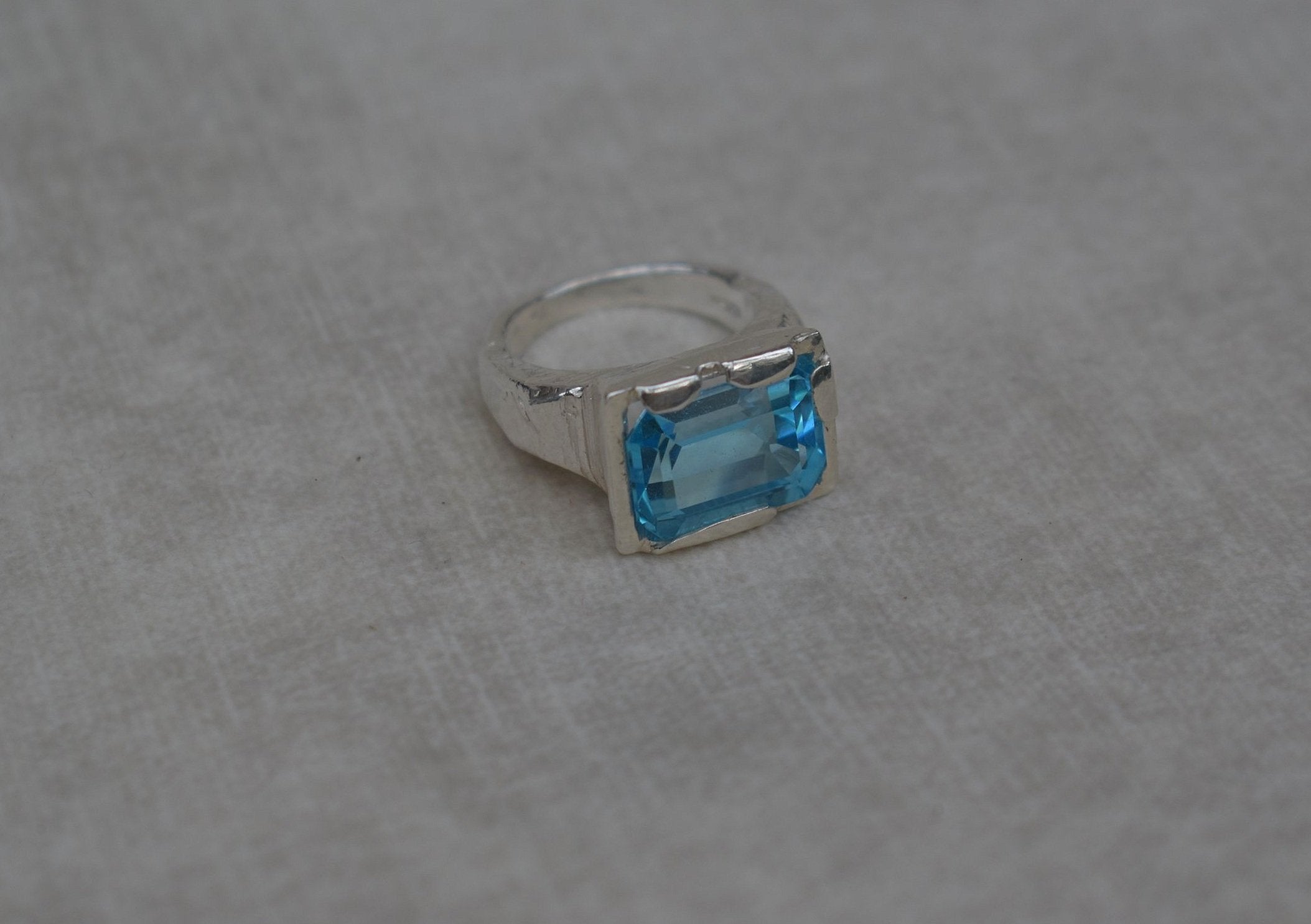 This is a beautiful emerald cut blue topaz set into a hand made solid silver setting. This stone is ethically sourced and the silver is 100% recycled
blue topaz statement ring cocktail party style large engagement ring in silver emerald cut stone ring diamond ring tiffany engagement sparkle silver stack ring
