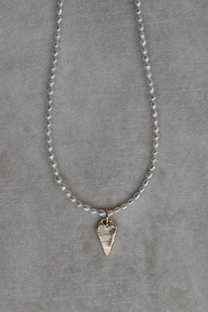 Rice shaped fresh water pearl hand strung necklace with 9ct gold tiffany heart charm. Pearl necklace measure 16” as standard with a 2” extension chain.All pieces are handmade to order. pearl charm necklace gold tiffany heart charm heart necklace tiffany pearl beaded strung necklace freshwater pearls pearl beach jewellery