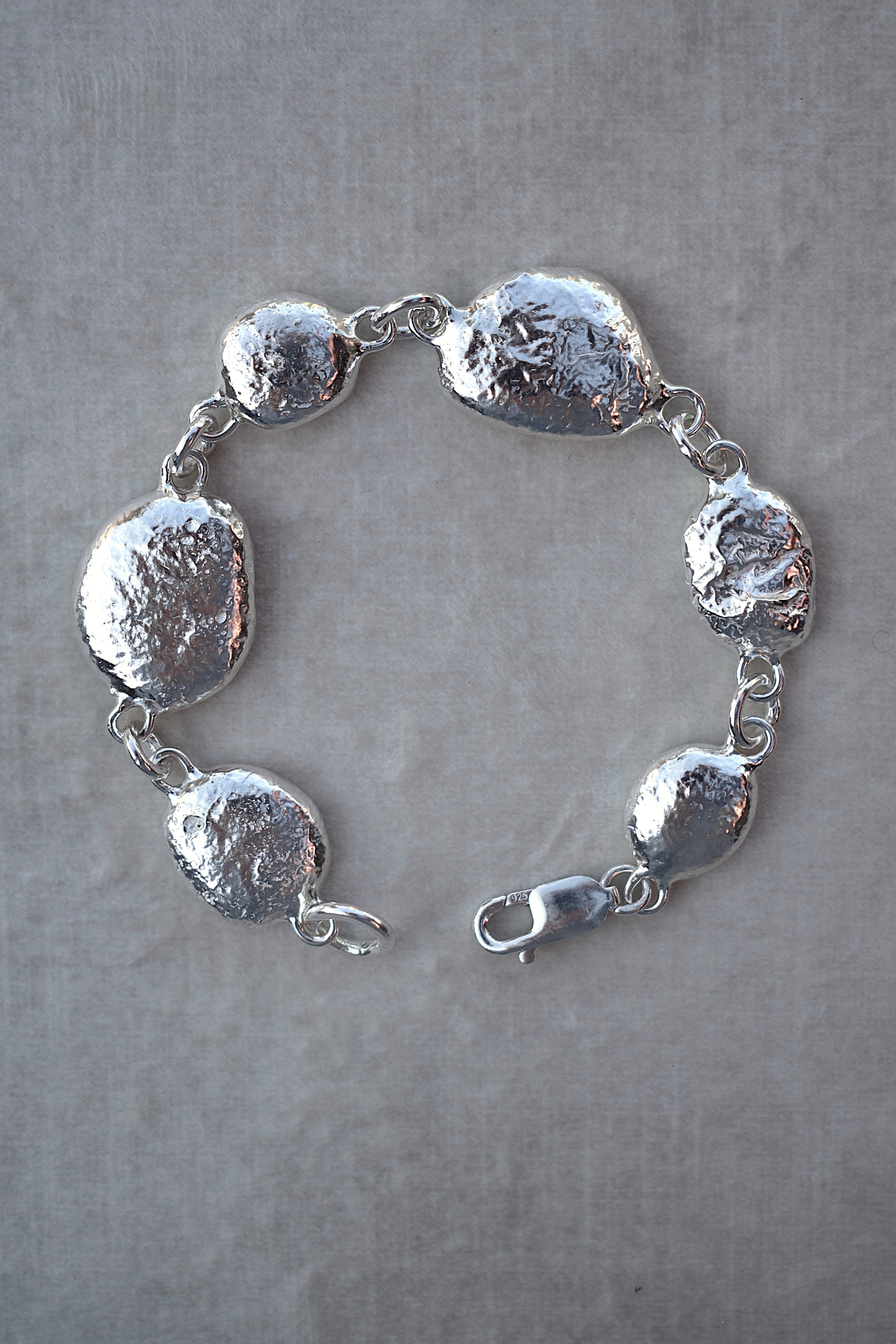 Unique silver pebble links make up this heavy bracelet. Made to order from recycled silver each pebble is totally unique. Hallmarked for silver. silver nugget chain bracelet silver charms linked together. heavy silver pebble bracelet
Chunky silver nugget heavy silver charm bracelet. Heavy link chain bracelet hermes style bracelet