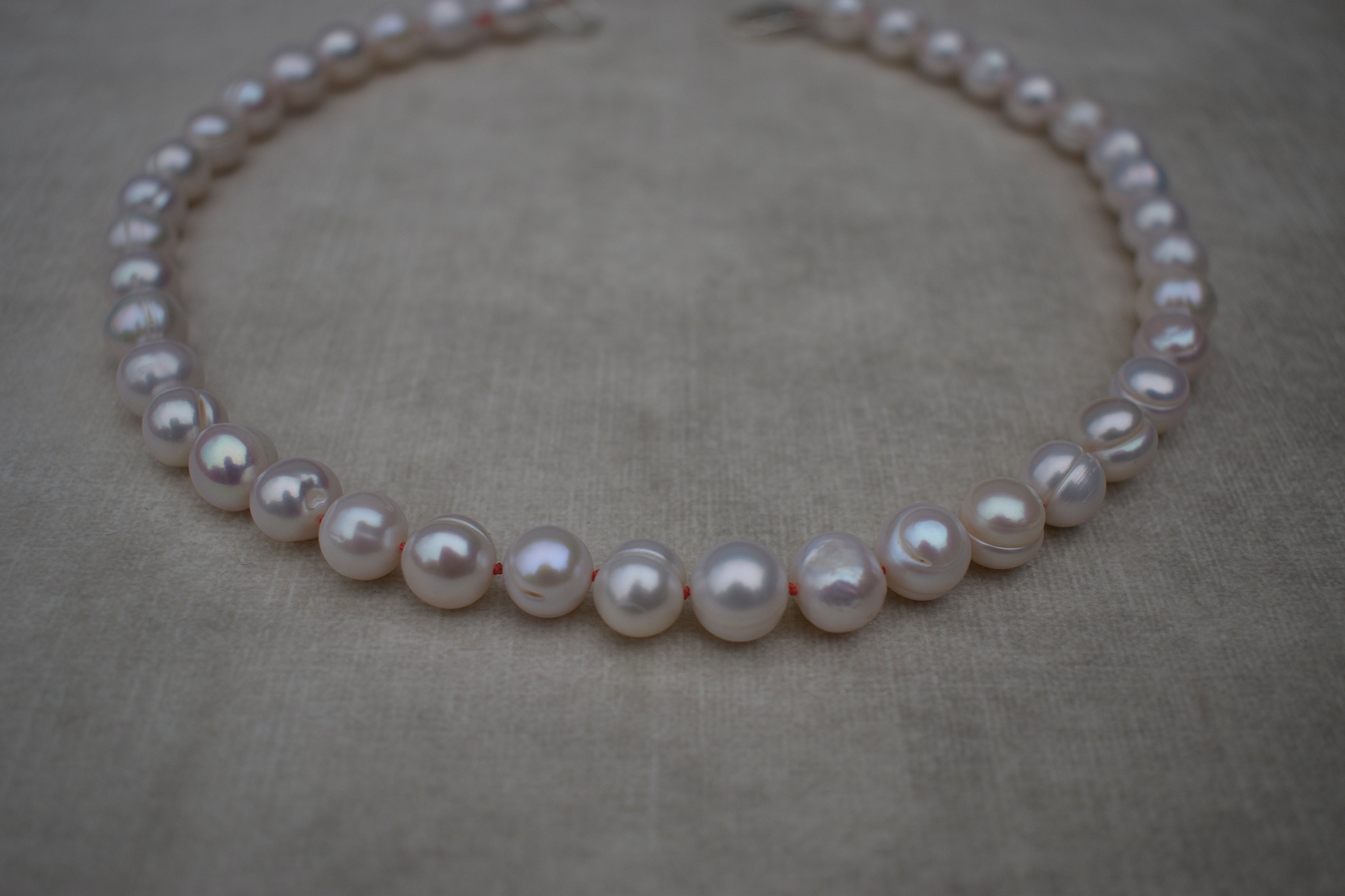 Large freshwater pearl hand strung necklace. Round, imperfect hand knotted with natural silk and set with a solid silver clasp. Pearl necklace choker style Ivory breakfast at tiffanys necklace