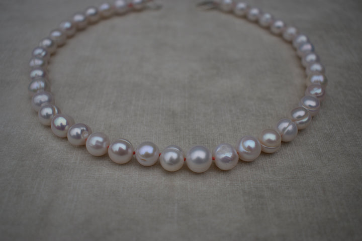 Large freshwater pearl hand strung necklace. Round, imperfect hand knotted with natural silk and set with a solid silver clasp. Pearl necklace choker style Ivory breakfast at tiffanys necklace