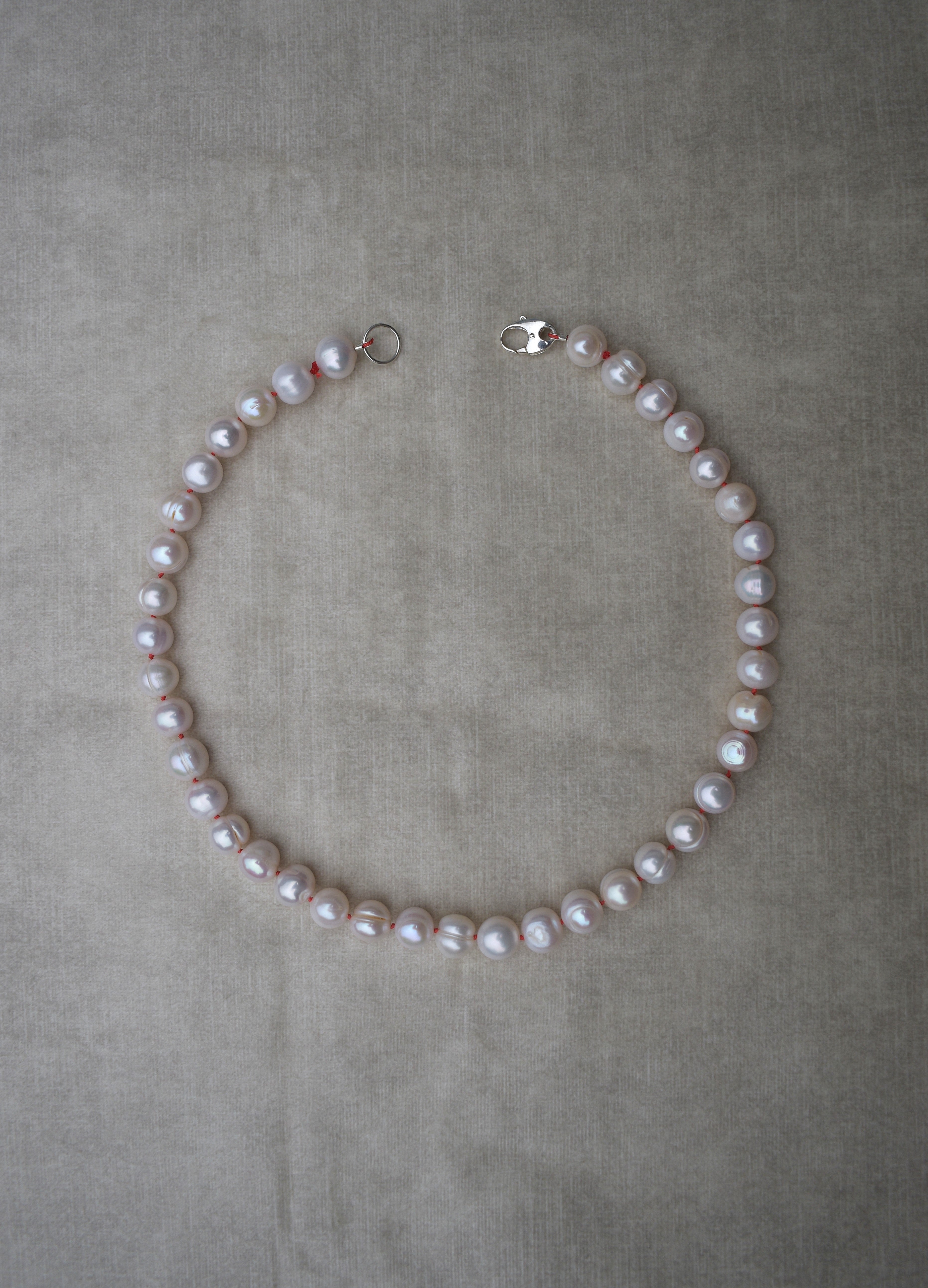 Large freshwater pearl hand strung necklace. Round, imperfect hand knotted with natural silk and set with a solid silver clasp. Pearl necklace choker style Ivory breakfast at tiffanys necklace