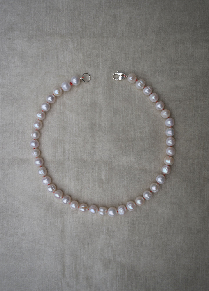 Large freshwater pearl hand strung necklace. Round, imperfect hand knotted with natural silk and set with a solid silver clasp. Pearl necklace choker style Ivory breakfast at tiffanys necklace