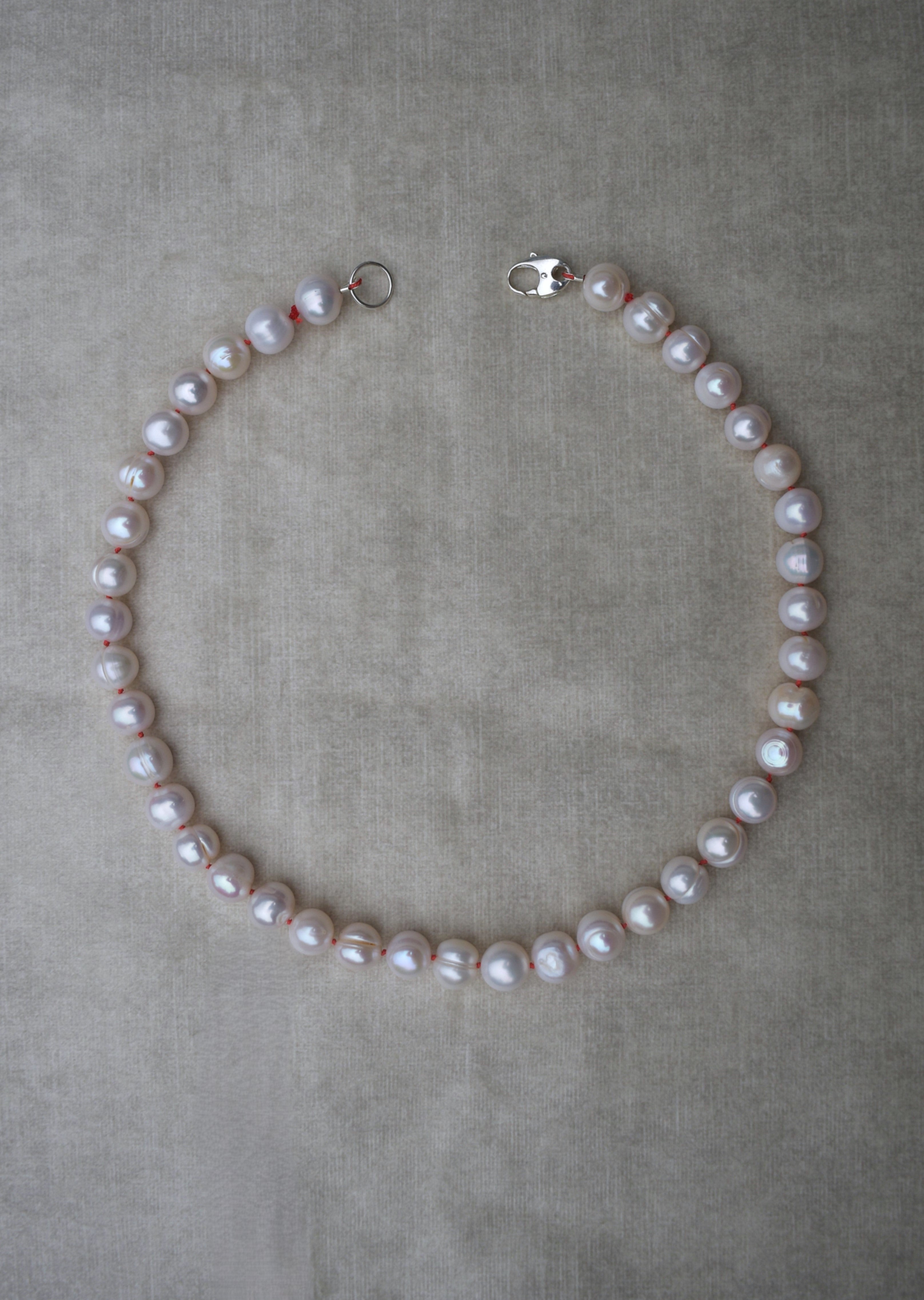Large freshwater pearl hand strung necklace. Round, imperfect hand knotted with natural silk and set with a solid silver clasp. Pearl necklace choker style Ivory breakfast at tiffanys necklace