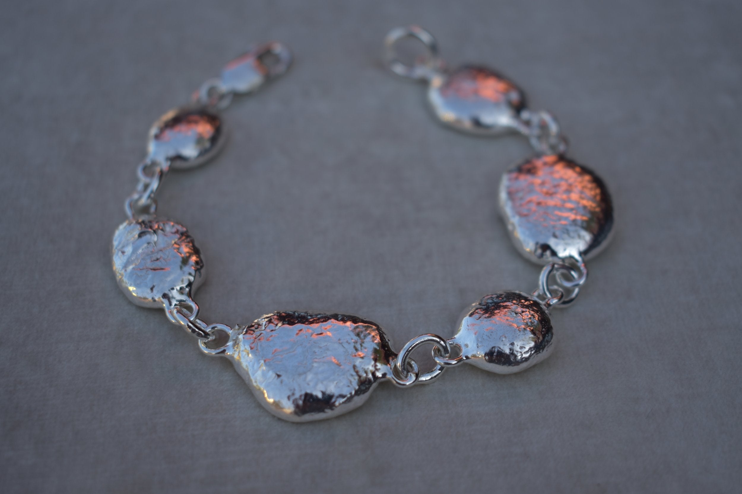 Unique silver pebble links make up this heavy bracelet. Made to order from recycled silver each pebble is totally unique. Hallmarked for silver. silver nugget chain bracelet silver charms linked together. heavy silver pebble bracelet
Chunky silver nugget heavy silver charm bracelet. Heavy link chain bracelet