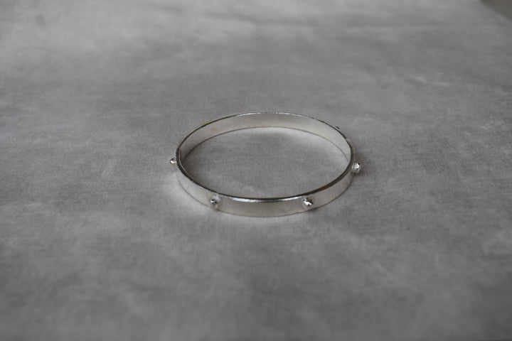 Thick solid silver hand sculpted bangle with medieval style studs. thick heavy silver cuff bangle round stack bangle personalised hand made bangle bracelet. Can be worn alone or with a combination of other bangles from the collection, thick or thin.