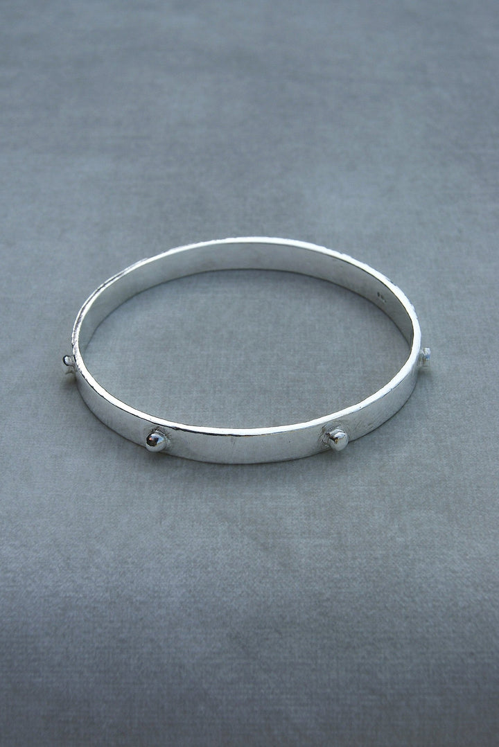 Thick solid silver hand sculpted bangle with medieval style studs. thick heavy silver cuff bangle round stack bangle personalised hand made bangle bracelet. Can be worn alone or with a combination of other bangles from the collection, thick or thin.