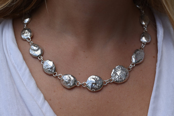 Silver pebble charms all linked together with a large handmade toggle clasp. This is a real heavy statement piece that is made to order and totally unique.
Unique silver pebble links make up this heavy statement necklace. Made to order from recycled silver each pebble is totally unique. Hallmarked for silver. silver nugget chain necklace silver charms linked together. heavy silver pebble pendant
Chunky silver nugget heavy silver chain necklace. Heavy link hermes chain choker.