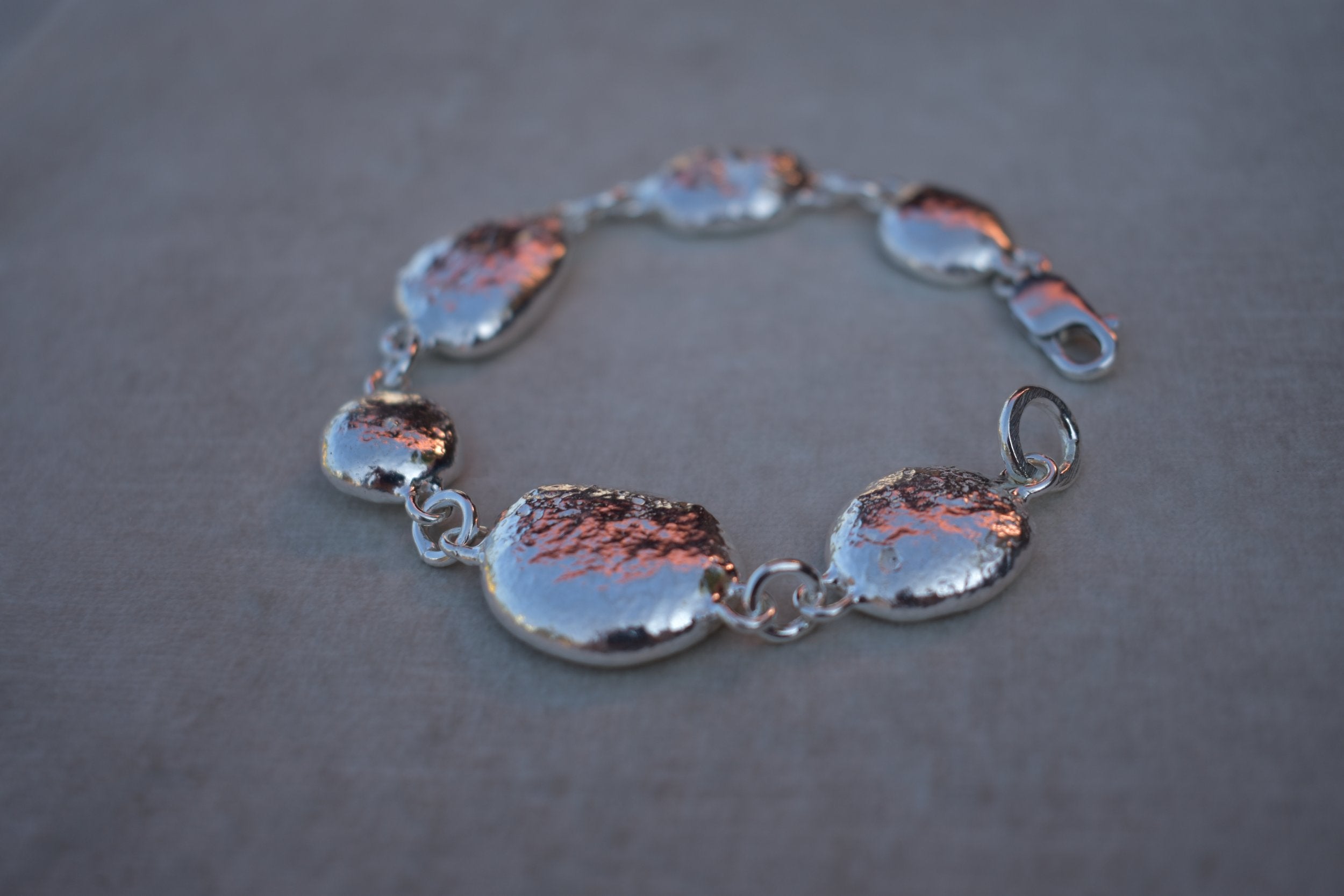 Unique silver pebble links make up this heavy bracelet. Made to order from recycled silver each pebble is totally unique. Hallmarked for silver. silver nugget chain bracelet silver charms linked together. heavy silver pebble bracelet
Chunky silver nugget heavy silver charm bracelet. Heavy link chain bracelet