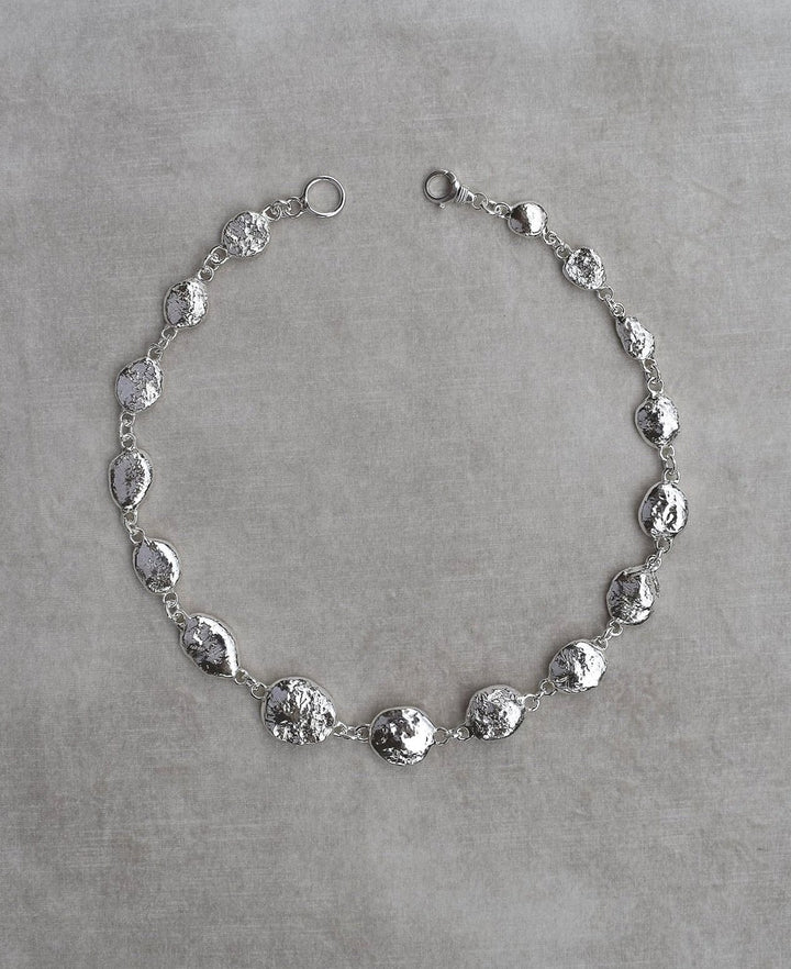 Silver pebble charms all linked together with a large handmade toggle clasp. This is a real heavy statement piece that is made to order and totally unique.
Unique silver pebble links make up this heavy statement necklace. Made to order from recycled silver each pebble is totally unique. Hallmarked for silver. silver nugget chain necklace silver charms linked together. heavy silver pebble pendant
Chunky silver nugget heavy silver chain necklace. Heavy link hermes chain choker.