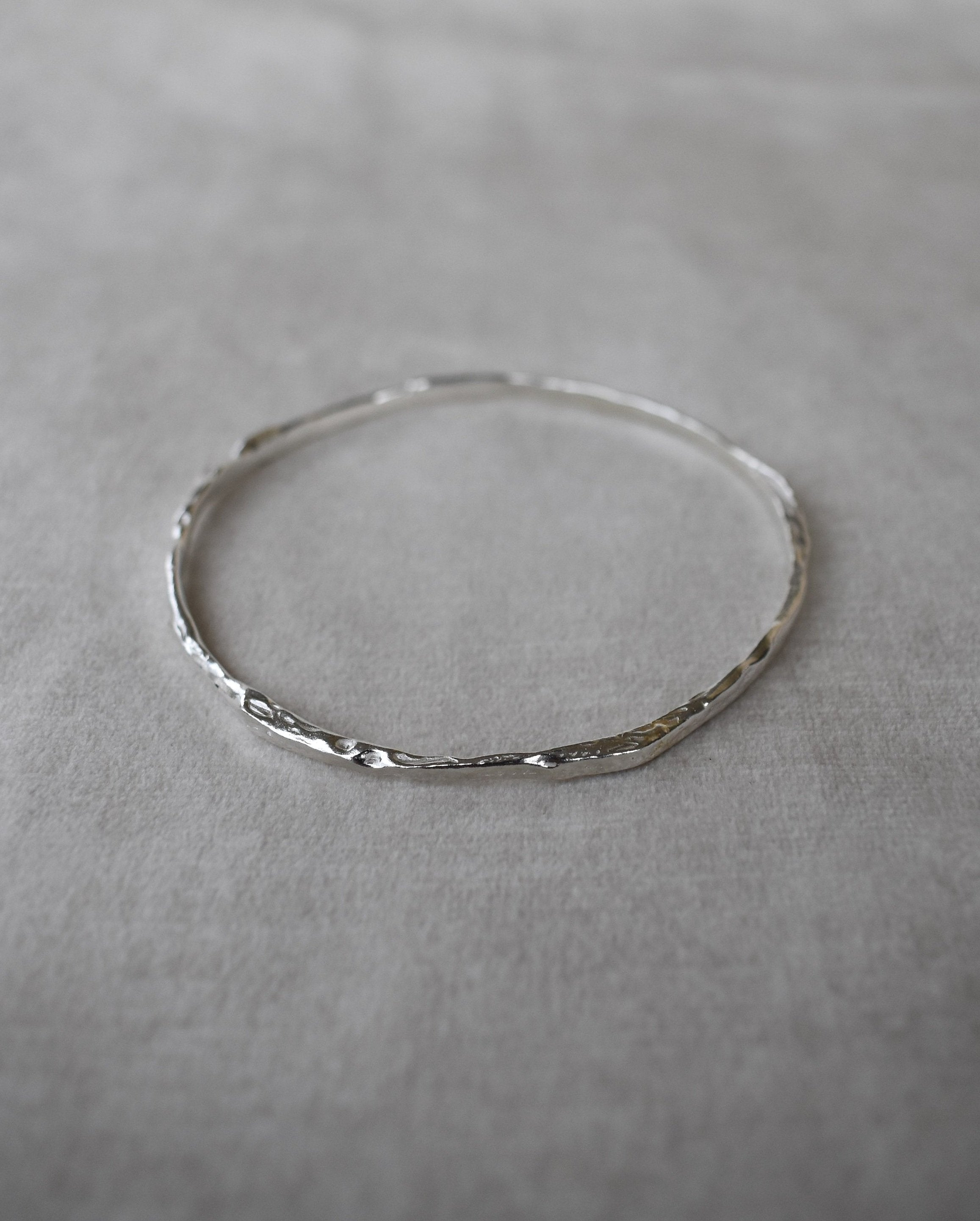 Solid silver round wire bangle nugget bangle organic texture bangle. handmade to order. silver bangle stack. Can be worn alone or with a combination of other bangles from the collection. Round thick silver stack bangle silver cuff charm bracelet round solid silver bangle ladies bracelet with charm personalised word bracelet bangle stack silver.