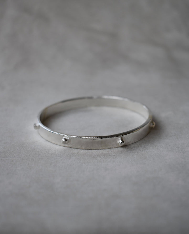 Thick solid silver hand sculpted bangle with medieval style studs. thick heavy silver cuff bangle round stack bangle personalised hand made bangle bracelet. Can be worn alone or with a combination of other bangles from the collection, thick or thin.