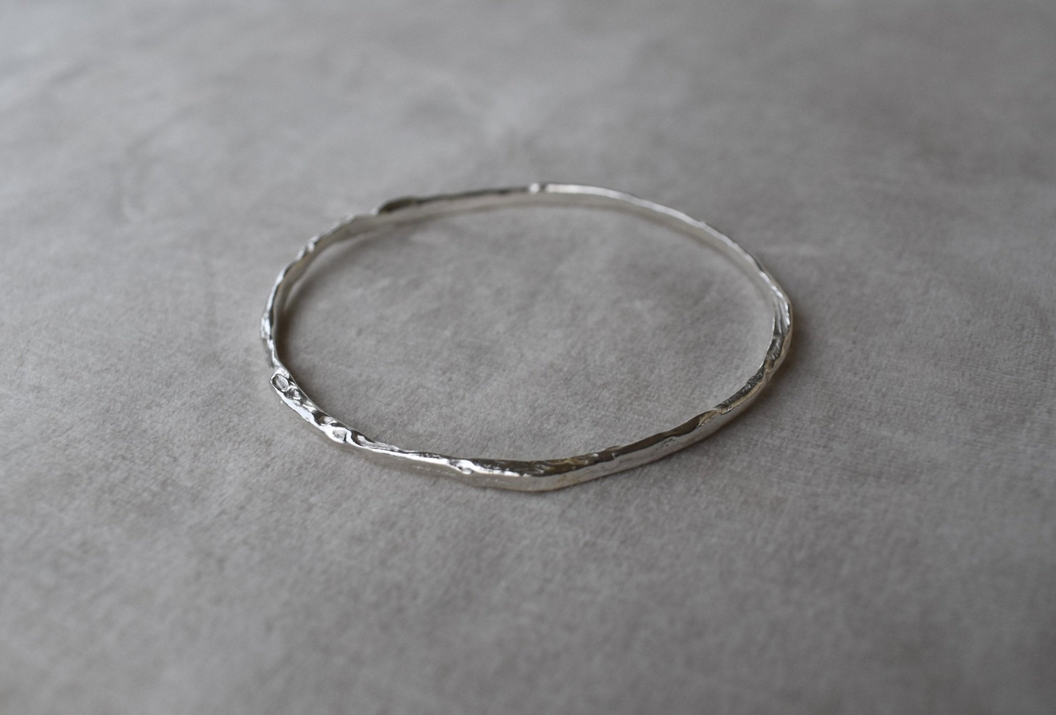 Solid silver round wire bangle nugget bangle organic texture bangle. handmade to order. silver bangle stack. Can be worn alone or with a combination of other bangles from the collection. Round thick silver stack bangle silver cuff charm bracelet round solid silver bangle ladies bracelet with charm personalised word bracelet bangle stack silver.