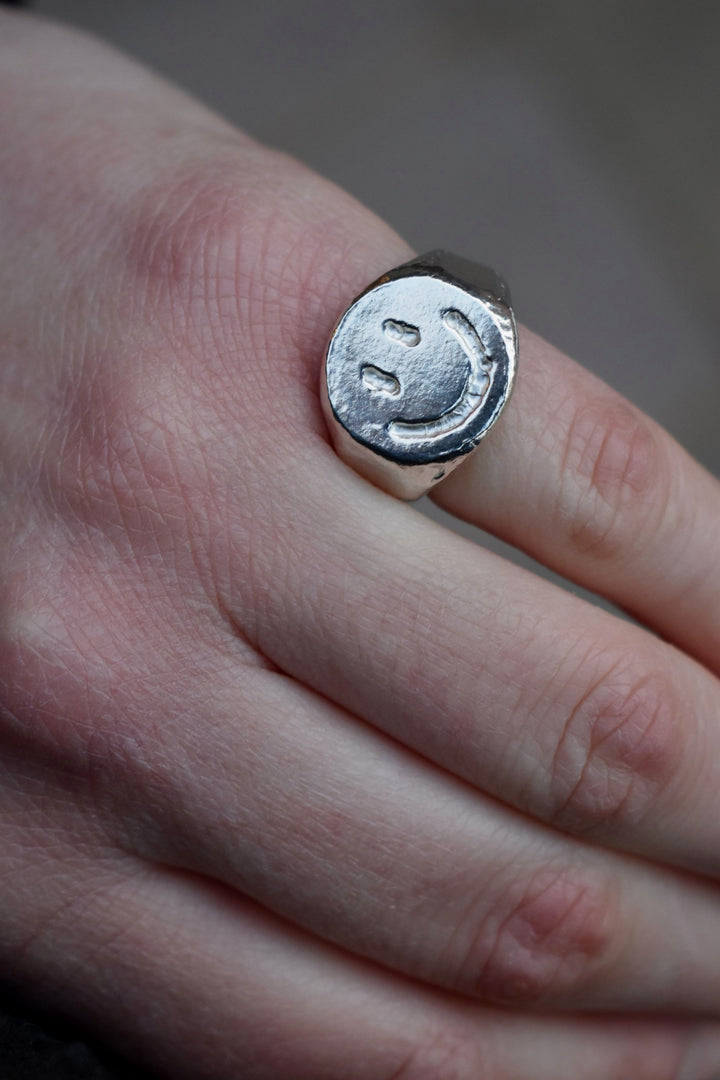 Solid silver smiley face ring hand carved signet ring with engraved smile face design. Available to order in 9ct gold or custom sizes. silver rave happy silver smiley face ring house music ring