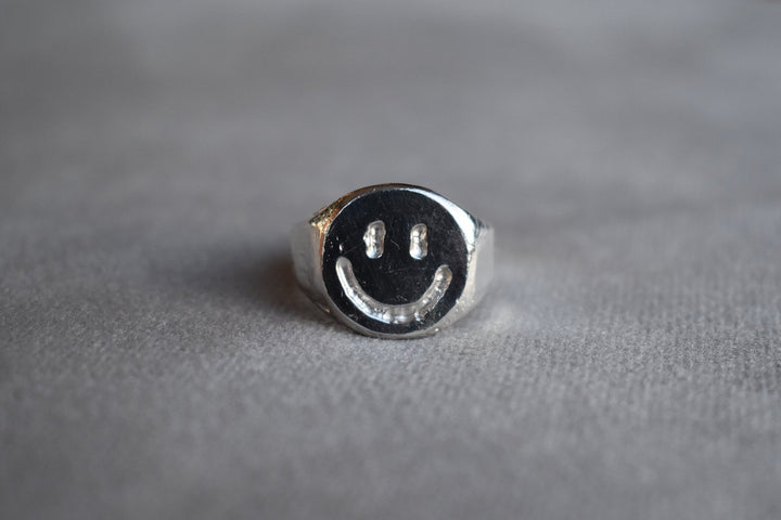 Solid silver smiley face ring hand carved signet ring with engraved smile face design. Available to order in 9ct gold or custom sizes. silver rave happy silver smiley face ring house music ring