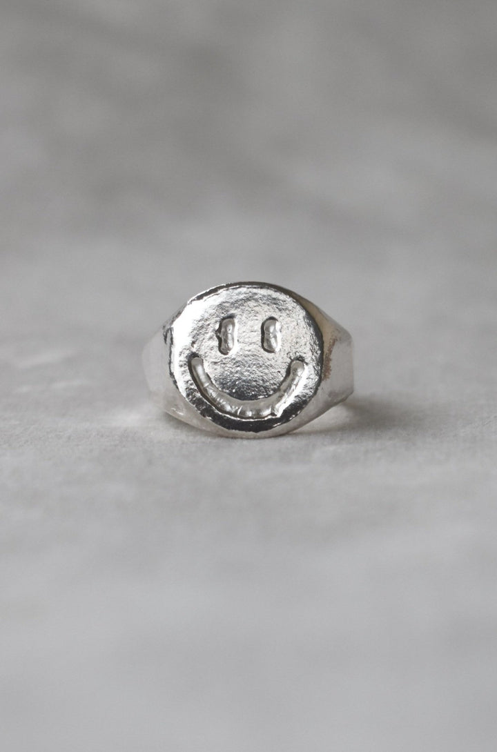 Solid silver smiley face ring hand carved signet ring with engraved smile face design. Available to order in 9ct gold or custom sizes. silver rave happy silver smiley face ring house music ring