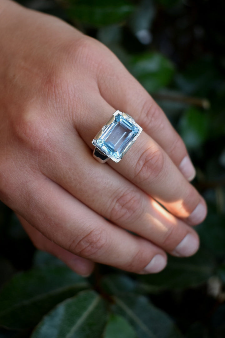 This is a beautiful emerald cut blue topaz set into a hand made solid silver setting. This stone is ethically sourced and the silver is 100% recycled 
blue topaz statement ring cocktail party style large engagement ring in silver emerald cut stone ring diamond ring tiffany engagement sparkle silver stack ring
aquamarine blue topaz engagement ring
