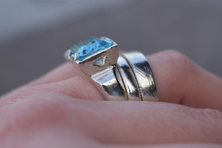 This is a beautiful emerald cut blue topaz set into a hand made solid silver setting. This stone is ethically sourced and the silver is 100% recycled 
blue topaz statement ring cocktail party style large engagement ring in silver emerald cut stone ring diamond ring tiffany engagement sparkle silver stack ring