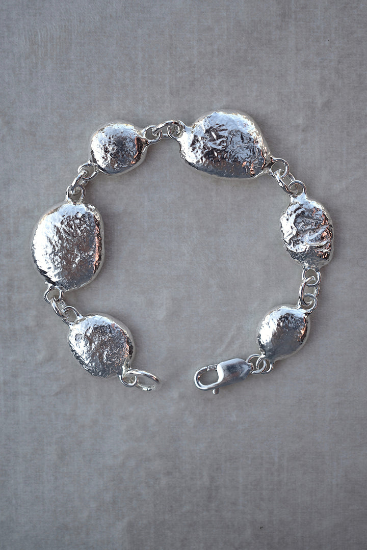 Unique silver pebble links make up this heavy bracelet. Made to order from recycled silver each pebble is totally unique. Hallmarked for silver. silver nugget chain bracelet silver charms linked together. heavy silver pebble bracelet
Chunky silver nugget heavy silver charm bracelet. Heavy link chain bracelet hermes style bracelet
