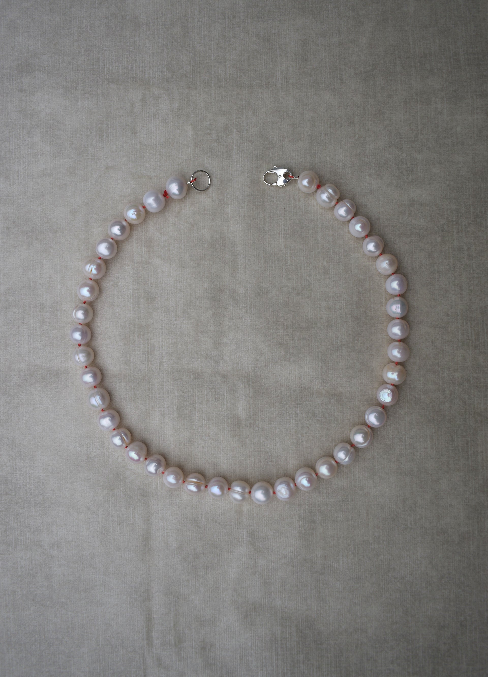 Large freshwater pearl hand strung necklace. Round, imperfect hand knotted with natural silk and set with a solid silver clasp. Pearl necklace choker style Ivory breakfast at tiffanys necklace