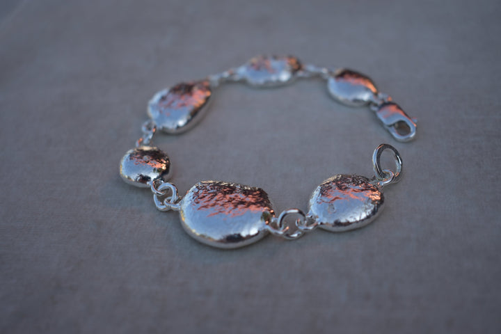 Unique silver pebble links make up this heavy bracelet. Made to order from recycled silver each pebble is totally unique. Hallmarked for silver. silver nugget chain bracelet silver charms linked together. heavy silver pebble bracelet
Chunky silver nugget heavy silver charm bracelet. Heavy link chain bracelet