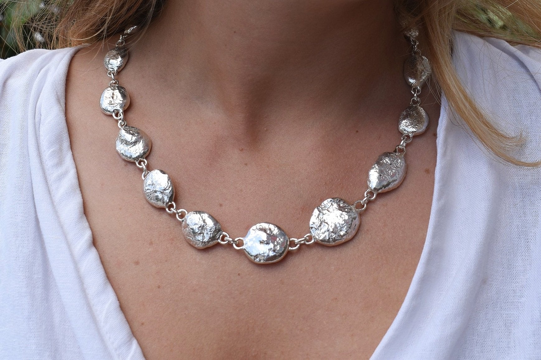 Silver pebble charms all linked together with a large handmade toggle clasp. This is a real heavy statement piece that is made to order and totally unique.
Unique silver pebble links make up this heavy statement necklace. Made to order from recycled silver each pebble is totally unique. Hallmarked for silver. silver nugget chain necklace silver charms linked together. heavy silver pebble pendant
Chunky silver nugget heavy silver chain necklace. Heavy link hermes chain choker.
