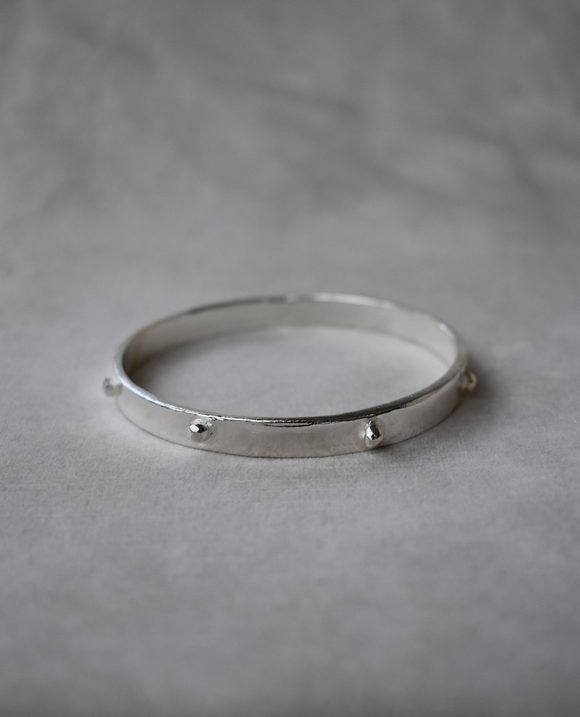 Thick solid silver hand sculpted bangle with medieval style studs. thick heavy silver cuff bangle round stack bangle personalised hand made bangle bracelet. Can be worn alone or with a combination of other bangles from the collection, thick or thin. 