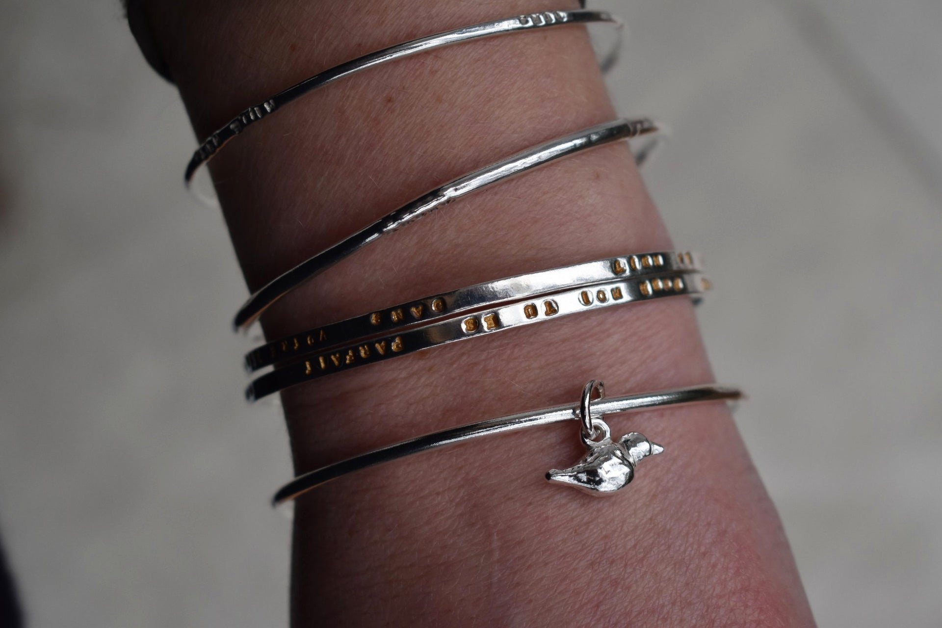 Solid silver round wire bangle with a mini bird charm. handmade to order. Solid silver round wire bangle with a mini bird charm. Can be worn alone or with a combination of other bangles from the collection. Round thick silver stack bangle silver cuff charm bracelet round solid silver bangle ladies bracelet with charm personalised word bracelet bangle stack silver. bird jewellery silver bird charm.