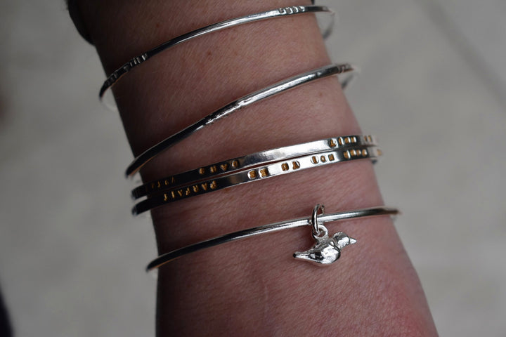 Solid silver round wire bangle with a mini bird charm. handmade to order. Solid silver round wire bangle with a mini bird charm. Can be worn alone or with a combination of other bangles from the collection. Round thick silver stack bangle silver cuff charm bracelet round solid silver bangle ladies bracelet with charm personalised word bracelet bangle stack silver. bird jewellery silver bird charm.
